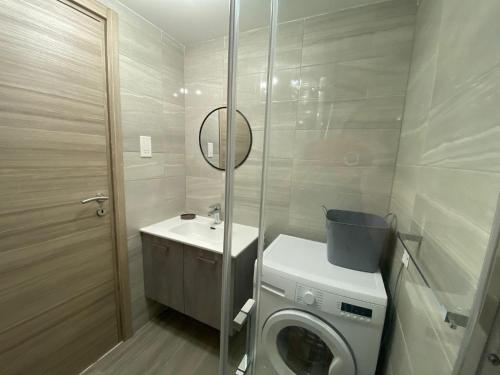 une salle de bain avec une machine à laver et un lavabo dans l'établissement Acciola Mimosa by Horizon Apartments Gozo, à Qbajjar