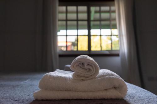 a white towel on a bed with a window at La Toldería - Casas de Campo in Trenque Lauquen