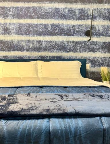 a bed in a room with a wall at SKY LUXURY Rooms Nettuno in Nettuno
