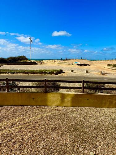 un banc en bois assis sur le côté d'une plage dans l'établissement Ocean SPOT, Vue sur la mer, Vacance Famille, Parking, Surf, 4P, à Hossegor