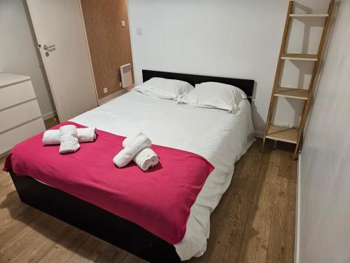 une chambre avec un grand lit avec des serviettes dessus dans l'établissement Quiet with garden, for 1 to 4, à Vannes