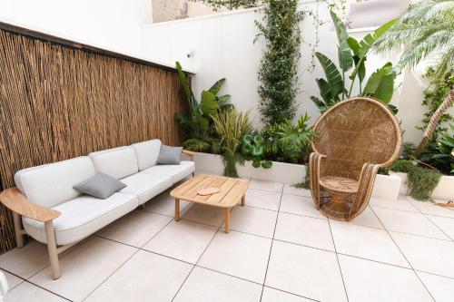 a patio with a couch and a table and plants at xenia apartments & suite in Siracusa