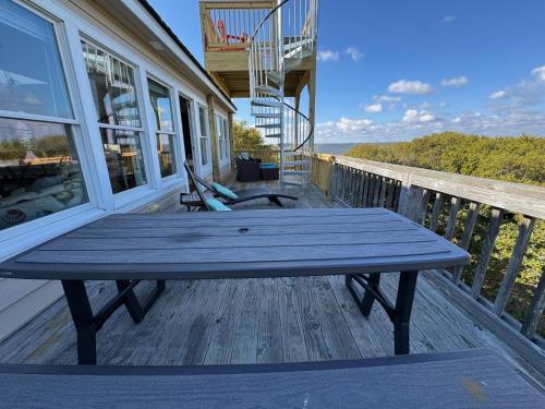 a picnic table on the porch of a house at Waterfront luxury w-beach resort-pool-golf-tennis-fishing & views! in Nags Head