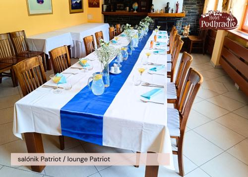 a long table with blue and white tablecloths at Hotel Podhradie in Považská Bystrica