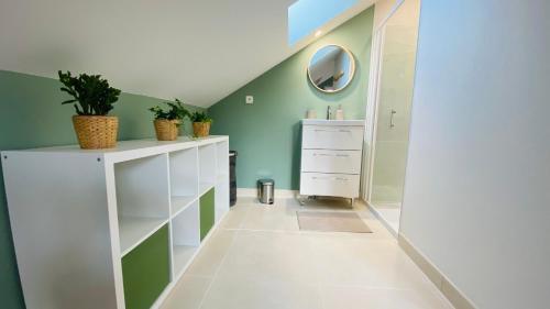 La salle de bains est pourvue de murs verts et de placards blancs. dans l'établissement Logement entier 4 personnes Eurodisneyland Paris, à Condé-Sainte-Libiaire