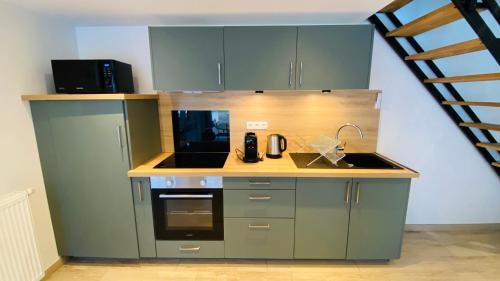 Il comprend une petite cuisine équipée d'une cuisinière et d'un évier. dans l'établissement Logement entier 4 personnes Eurodisneyland Paris, à Condé-Sainte-Libiaire