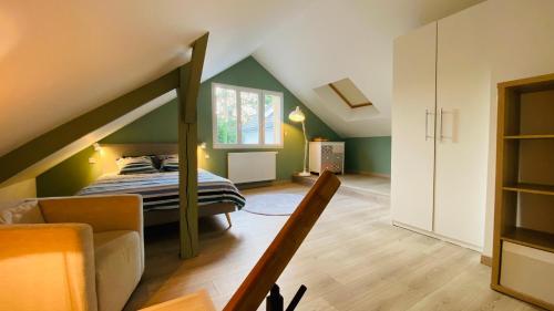 - une chambre mansardée avec un lit et un canapé dans l'établissement Logement entier 4 personnes Eurodisneyland Paris, à Condé-Sainte-Libiaire