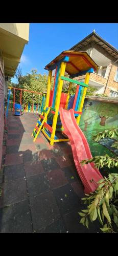 a playground with a slide and a play structure at Къща за гости Беглик таш 3 in Primorsko