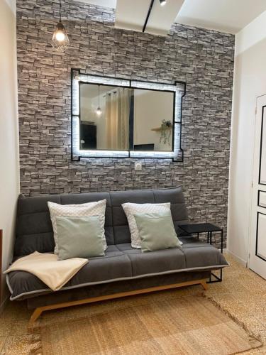 - un canapé noir dans une pièce dotée d'un mur en briques dans l'établissement Studio Nîmes, 6 rue Nationale, à Nîmes