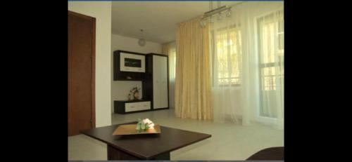 a living room with a table and a window at Къща за гости Беглик таш 3 in Primorsko