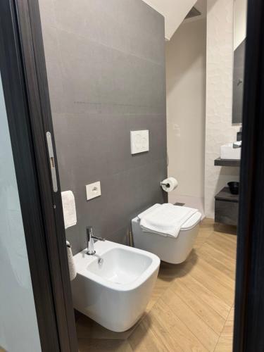 a bathroom with a white sink and a toilet at SKY LUXURY Rooms Nettuno in Nettuno