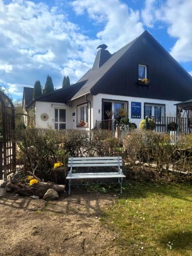 a white house with a bench in front of it at Sirisferienhaus in Kurort Steinbach-Hallenberg