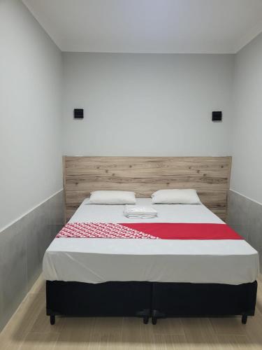 a bedroom with a large bed with a wooden headboard at Hotel Anália Franco in Sao Paulo