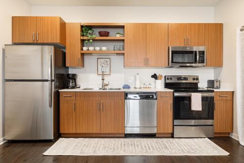 a kitchen with wooden cabinets and stainless steel appliances at Trailside Charm TART Trail Downtown in Traverse City