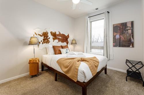 a bedroom with a large bed with white sheets and a window at Trailside Charm TART Trail Downtown in Traverse City