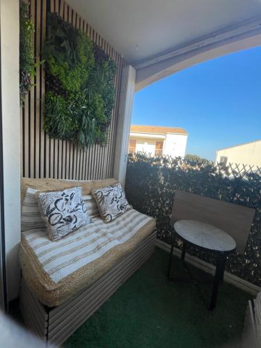 Elle comprend un petit balcon avec un lit et une table. dans l'établissement Appartement avec Clim et balcon, au Grau-du-Roi