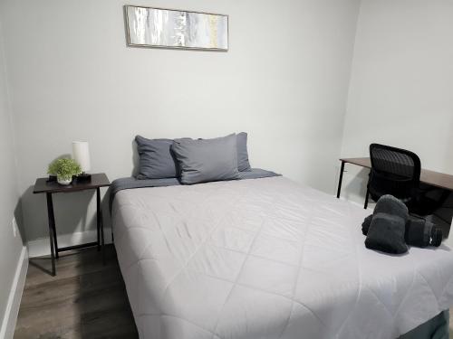 a bedroom with a white bed and a black chair at Homey 2br Home Near Dt & Airport in Austin
