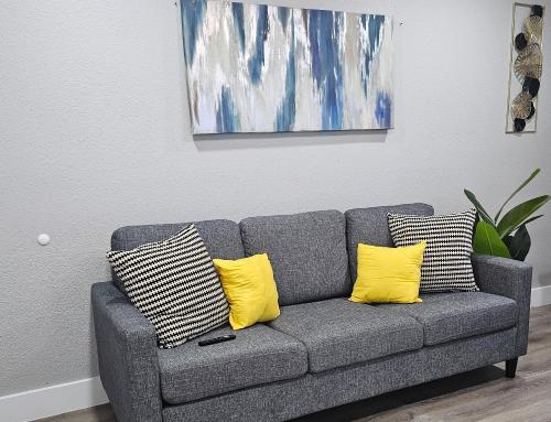 a gray couch with two yellow pillows in a living room at Homey 2br Home Near Dt & Airport in Austin