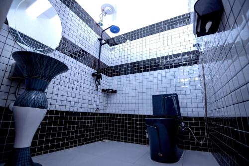 a bathroom with a black and white tiled wall at Vegas Chillout Suites in Kampala