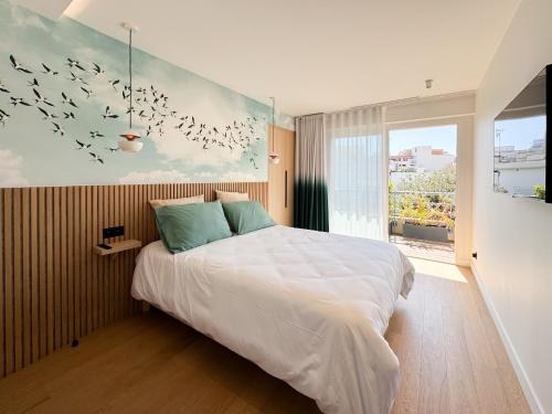 - une chambre avec un lit et une peinture d'oiseaux dans l'établissement Cavalaire plein centre, Appartement design 70m2 à 2mn de la plage - Garage privé -Terrasse, à Cavalaire-sur-Mer