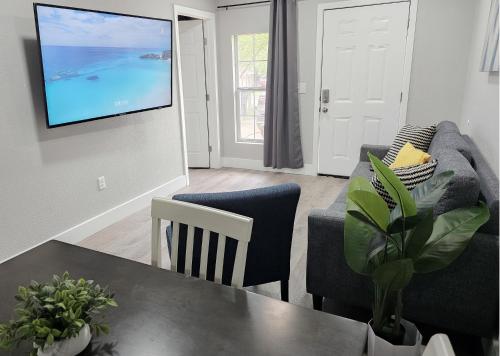 a living room with a table and a tv on a wall at Homey 2br Home Near Dt & Airport in Austin