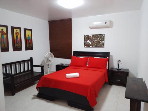 een slaapkamer met een rood bed en een rode deken bij Hotel La Casona Valledupar in Valledupar
