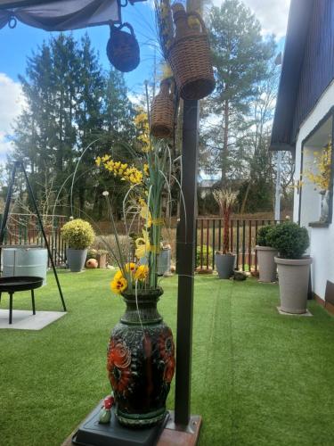 a vase filled with yellow flowers sitting on a table at Sirisferienhaus in Kurort Steinbach-Hallenberg