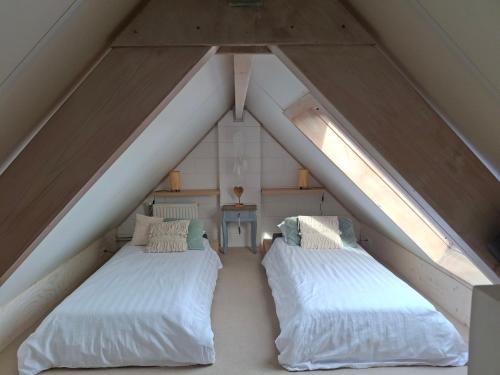 two beds in the middle of a attic at Huisje Suus, inclusief jacuzzi, kano en kajak in Zuid-Scharwoude