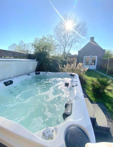 a jacuzzi tub in the backyard of a house at Huisje Suus, inclusief jacuzzi, kano en kajak in Zuid-Scharwoude