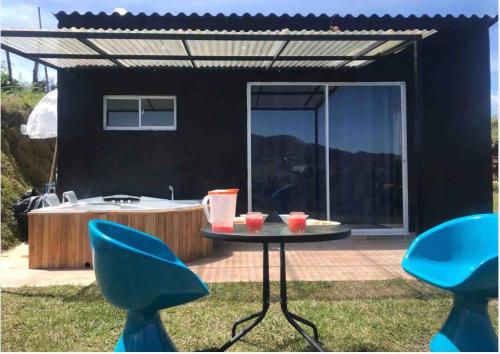 a patio with a table and chairs and a tub at Cabaña Celestial in Guarne