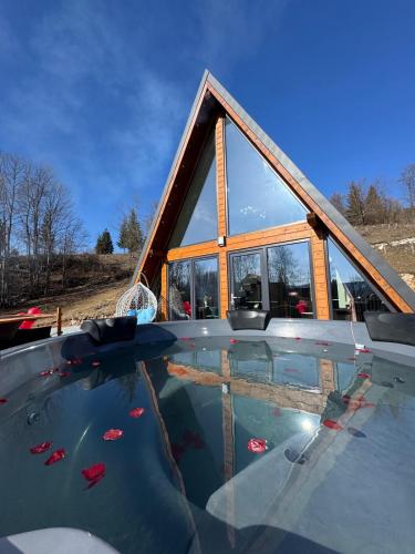 a house with a pool in front of it at Cabana A Frame In Jomp in Gîrda de Sus