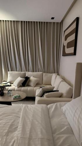 a living room with a white couch and a table at استديو برق بطابع فندقي بحي حطين in Riyadh