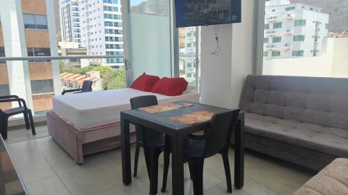 a bedroom with a bed and a table and chairs at Apartamento El Rodadero con balcón in Gaira