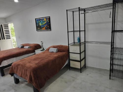 1 dormitorio con 2 camas y estante para libros en Casa los Sauces, en Tepic