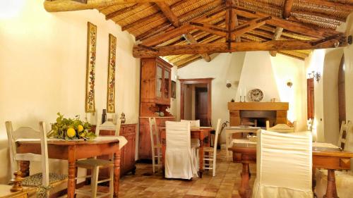 una sala da pranzo con tavoli e sedie e una cucina di Il Borgo dell'Arcangelo a Barùmini