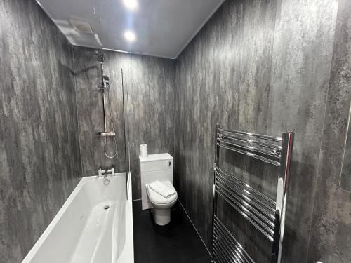 a bathroom with a toilet and a bath tub at Albion Apartment by Klass Living Coatbridge in Coatbridge