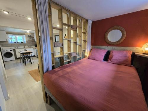 une chambre avec un grand lit et une cuisine dans l'établissement Studio de charme avec jardin au Quatre-Moulins, à Brest