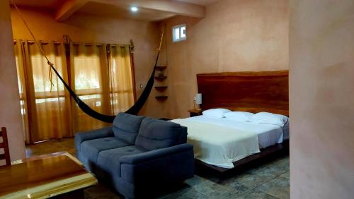 a bedroom with a bed and a blue chair at Casa XhunaXhia in Zipolite