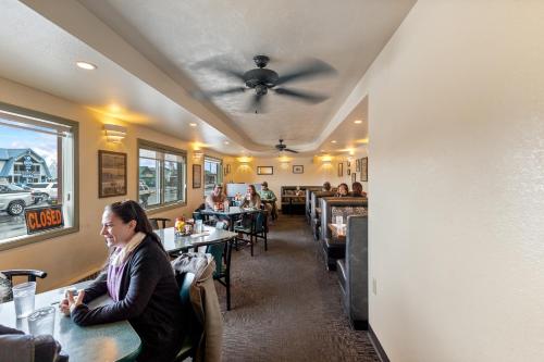 a woman sitting at a table in a restaurant at Breeze Inn Hotel in Seward