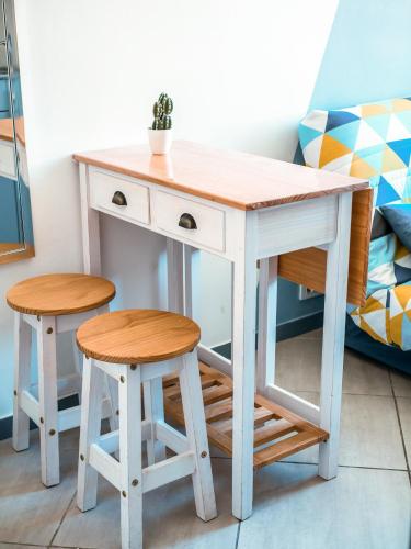 - un bureau et deux tabourets à côté d'un lit dans l'établissement PORT - Charmant Studio, à Nice