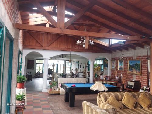 Una gran sala de estar con una mesa de billar. en Private Casita near UIO airport, en Hacienda Otón