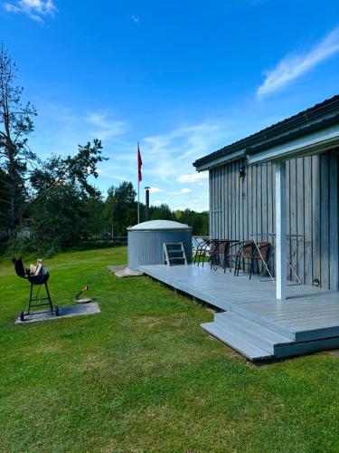 a large deck next to a building with a picnic table at Sodyba Po klevu in Molėtai