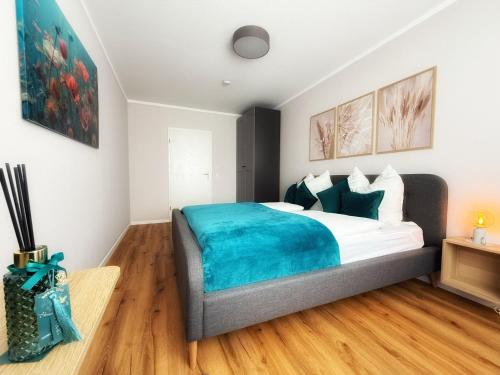 a bedroom with a bed with a blue blanket at Carrée 31 Balkon, Privatparkplatz, Aufzug, Kaffee in Chemnitz