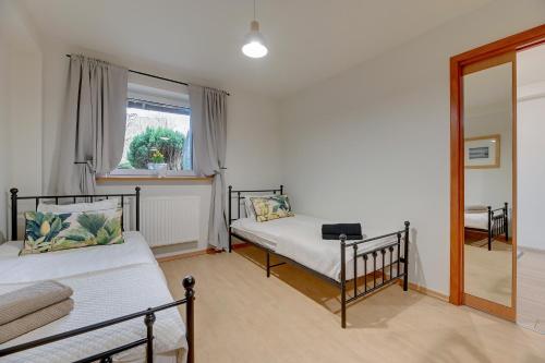 a bedroom with two beds and a window at Apartament 48 in Gdańsk