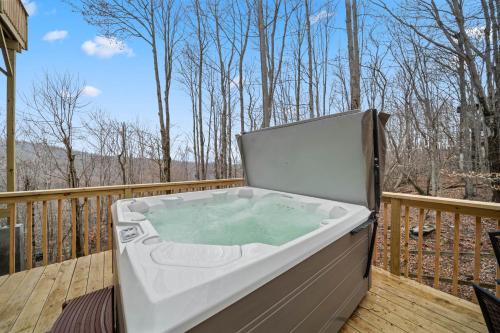 a hot tub on the deck of a house at On Beech Time in Beech Mountain