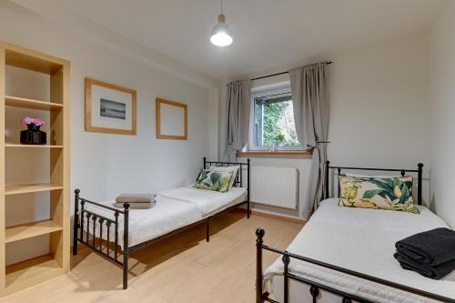 a bedroom with two beds and a window at Apartament 48 in Gdańsk