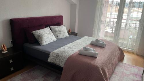 una camera da letto con un letto su cui sono appoggiati due asciugamani di Apartment Voska a Ohrid