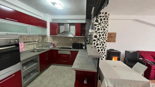 una cucina con mobili rossi ed elettrodomestici in acciaio inossidabile di Apartment Voska a Ohrid