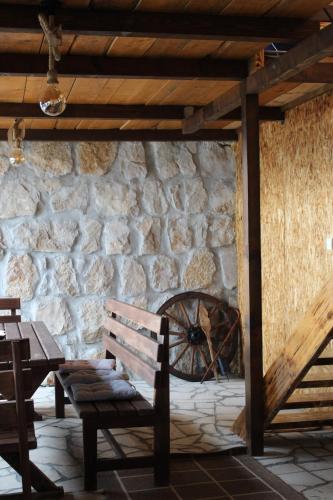 a stone wall with a wooden bench and a wheel at Lake house Zoya in Nikšić