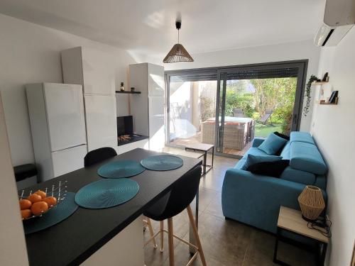 Il comprend une cuisine et un salon doté d'un canapé bleu. dans l'établissement Studio Port de Porto-Vecchio, à Porto-Vecchio